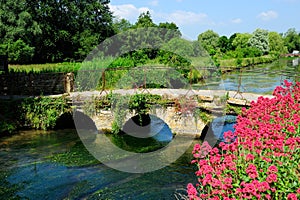 Stone arch bridge over the canal in beautiful cottage in Cotswolds, England, UK