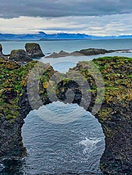 Stone arch called Gatklettur between the villages of Arnarstapi and Hellnar