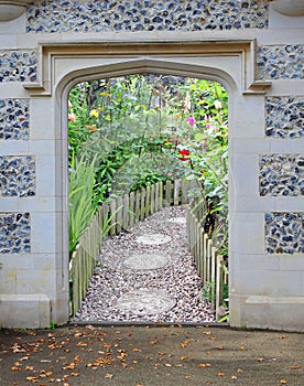Stone arch gateway door entrance to beautiful garden flowers plants