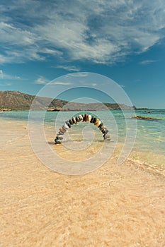 Stone arch made of pebbles on the beach