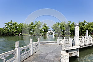 Stone arch and zigzag bridge in lake