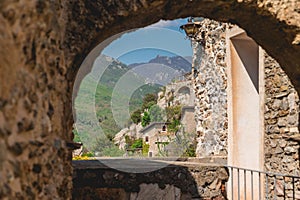 Stone archway overlooking the rolling hills and quaint villages in Castelvecchio di Rocca Barbena