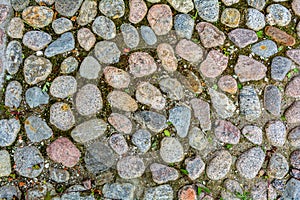 Stone background of pavement with rough granite boulders. Medieval cobble paving