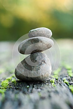 Stone balance of pebbles on wooden table in outdoor