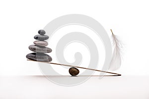 Stone balance with plume. Concept of hard and easy.