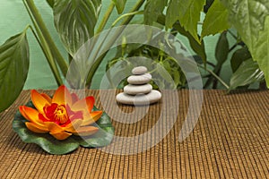 Stone balance pyramid, orange lily, green leaves