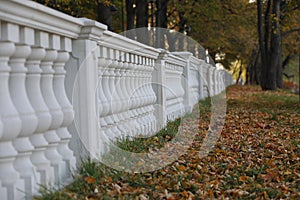 Stone balustrade long row on the colorful background of the autumn Park.