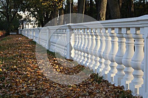 Stone balustrade long row on the colorful background of the autumn Park.