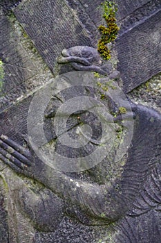 Stone bas-relief of the face of Christ with a crown of thorns and holding the cross.