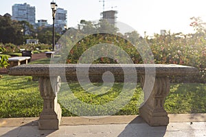 Stone bench in city park at sunset