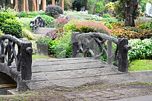 Stone black bridge in flowers garden