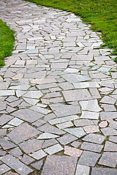 The Stone block walk path with green grass background