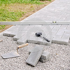 Stone blocks with tool for paving laying down background. Hausework architect concept