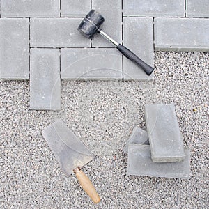Stone blocks with tool for paving laying down background. Hausework architect concept