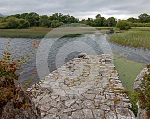 Stone boat dock of ancient castle ruins McCarthy Mor on Lake Lough Leane at Killarney on the Ring of Kerry in Ireland photo