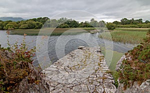 Stone boat dock of ancient castle ruins McCarthy Mor on Lake Lough Leane at Killarney on the Ring of Kerry in Ireland photo