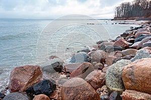 Stone boulders on the sea coast, cloudy inclement weather at sea, rocky seashore