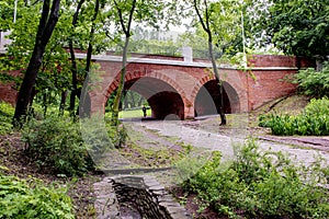 stone brick vintage bridge in the park on a summer day in the grass