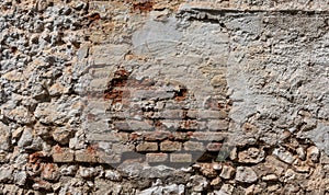 Stone and brick wall covered with lime. Old and rustic texture