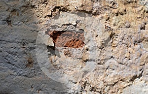 Stone and brick wall covered with lime. Old and rustic texture