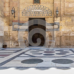Stone bricks wall and opened door leading to passage at the courtyard of Sultan Barquq Mosque, Cairo
