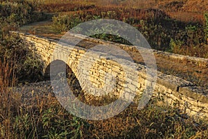 Stone bridge with arch over dry creek