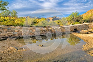 Stone bridge on a creek with reflective water at Sabino State Park in Tucson, Arizona