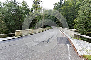 Stone bridge crosses a stream in Eagle mountains Orlicke hory during summer time.