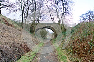 Stone bridge crossing a country path.