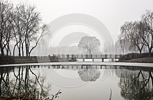 A Stone Bridge on the Ice Lake in Fog Day photo
