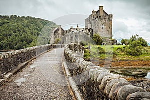 A stone bridge leads to Eilean Donan Castle in Scotland, UK