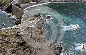 Stone bridge and narrow cliff trail above the Bay of Biscaya