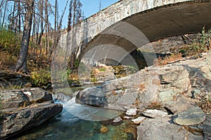 STONE BRIDGE OVER BARING CREEK ON THE GOING TO THE SUN ROAD IN GLACIER NATIONAL PARK IN MONTANA USA