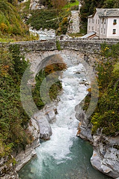 Stone bridge over the river Mera in the old Swiss village Promontogno