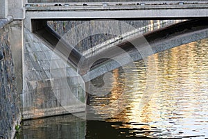 setting sun is reflected in the river below the bridge