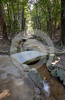 The stone bridge over a stream in the forest park of Heian-jingu Shrine. Kyoto. Japan