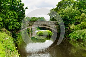 Stone bridge over the White Cart Water in Pollok Country Park in photo