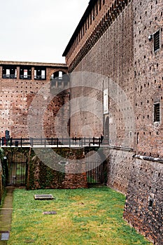 Stone bridge with railings near the wall of the Castello Sforzesco. Milan, Italy