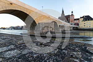 Stone bridge and skyline of Regensburg with selective focus on foreground