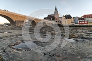 Stone bridge and skyline of Regensburg with selective focus on foreground