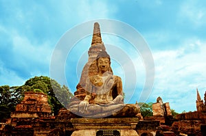 Stone Buddha sitting in front of a pagoda