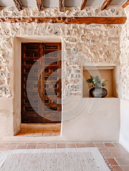 Stone building entrance with a potted plant. Organic Farm, Ibiza, Spain