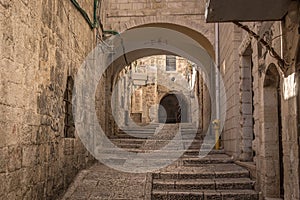 The stone-built alley with the arch and stairs deep in Jerusalem Old Town in Jerusalem.