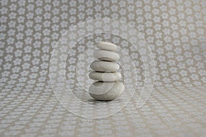 Stone cairn on gray background with flowers stars, five stones tower, simple poise stones, simplicity harmony and zen balance