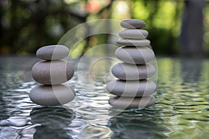 Stone cairn on green blurry background, light pebbles and stones