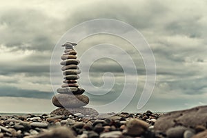 Stone cairn on green blurry background, pebbles and stones