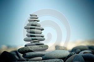 Stone cairn on green blurry background, pebbles and stones