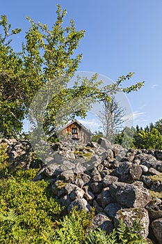 Stone cairn with an old cottage and fruit tree