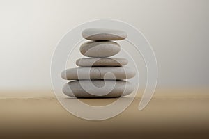 Stone cairn on striped grey white background, five stones tower, simple poise stones, simplicity harmony and balance