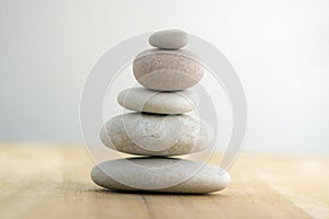 Stone cairn on striped grey white background, five stones tower, simple poise stones, simplicity harmony and balance, rock zen